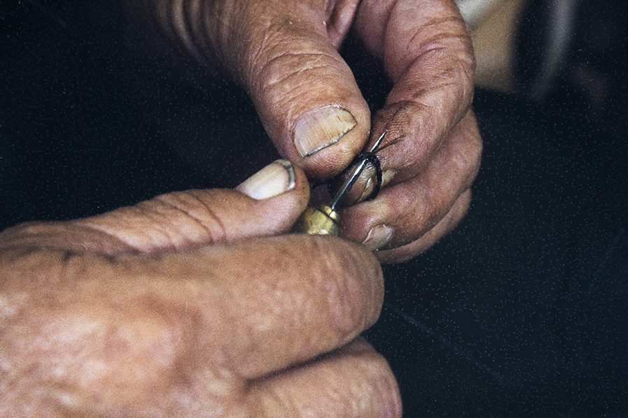 2282_027_Valmis Kun kiertäminen päättyy, avataan tästä kohtaa kierre naskalilla ja harjas pujotetaan tästä läpi solmun tekemiseksi v. 1982. Kuva: Kari Jämsén / KUHMU