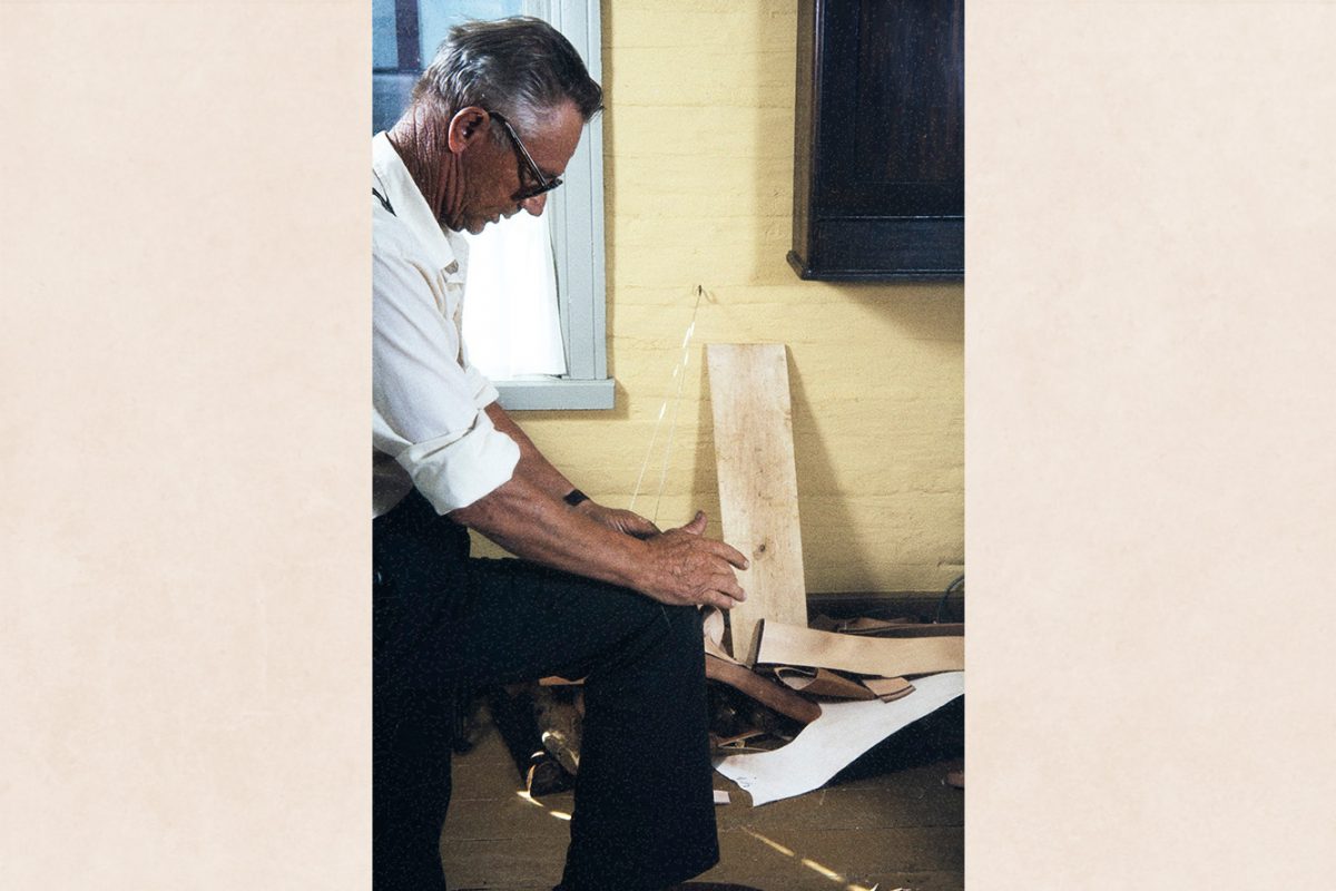 2282_023_netti Vihtori Heikkinen twists the pitch thread, 1982. The best way to twist the whole thread is with a worn trouser hitch or against a leather patch glued to the fabric. Photo: Kari Jämsén / KUHMU