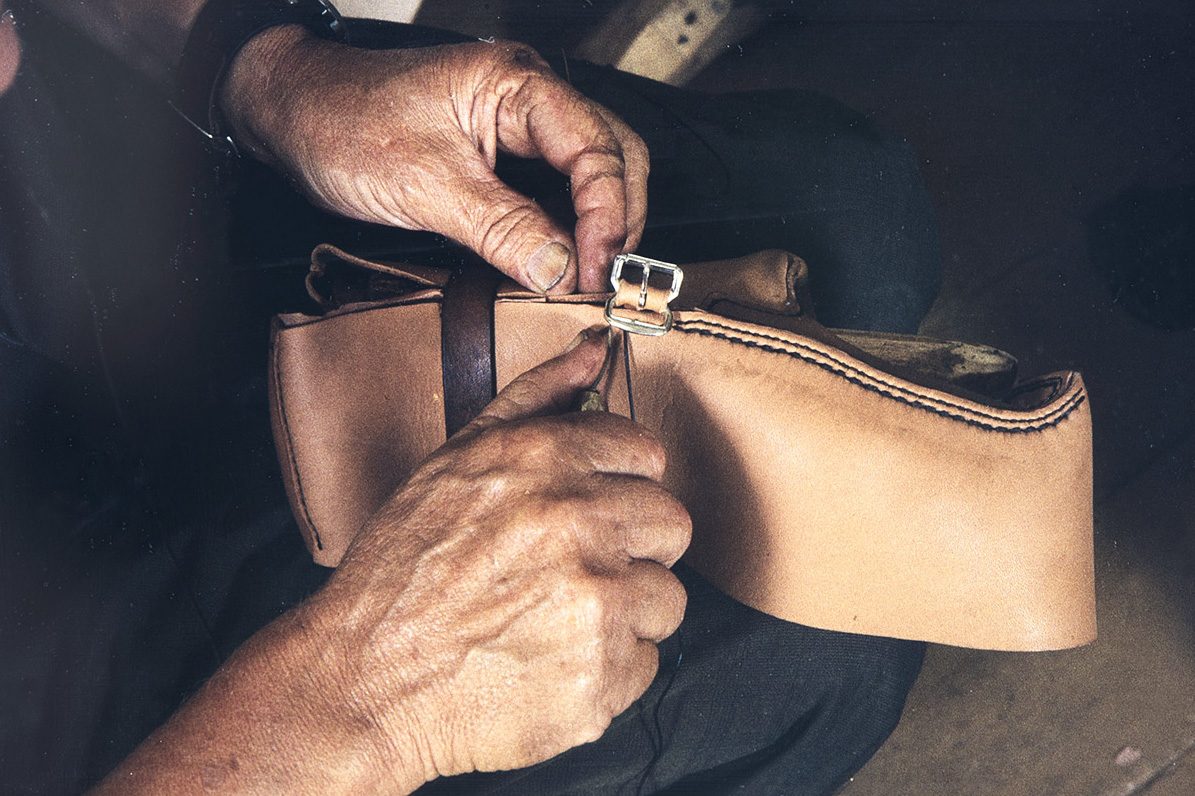 33_2282_098_valmis_netti When sewing the ankle part, the buckle is sewn at the same time to the seam, 1982. Photo: Kari Jämsén / KUHMU