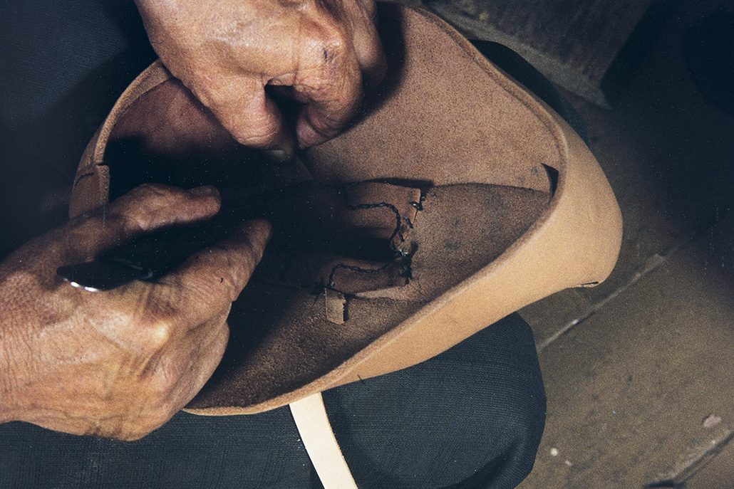 39b_2282_115_valmis_netti The ankle sewing threads are tied inside the ankle and the ends of the buckle straps are cut off from the inside, 1982. Photo: Kari Jämsén / KUHMU