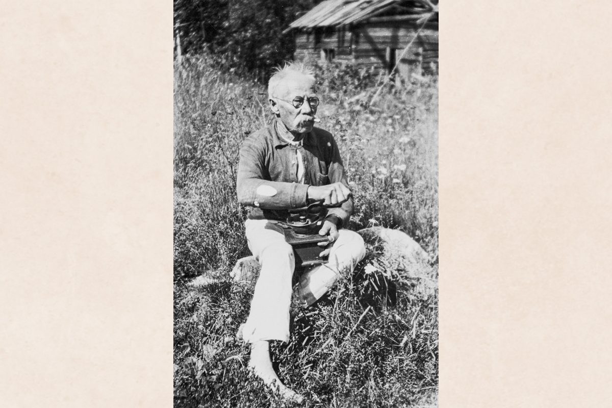 4413,82_valmis Telkko’s Tuakko (Taavetti Halonen) grinds coffee sitting on a rock in Telkonsaari, Haminalahti, 1939. Photo: Paavo Hänninen / KUHMU
