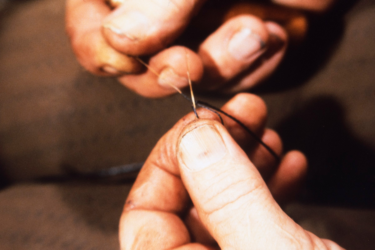 5000_0025_netti Finally, a knot is made to hold the bristle in the pitch thread, 1978. Photo: Juha Miettinen / KUHMU