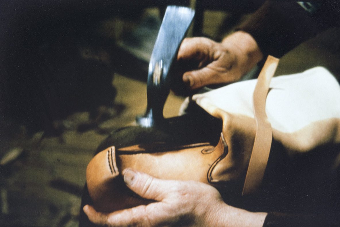 55_5000_0074_valmis_netti The shoe cover (vamp) and the sides (edges) of the shoe can be smoothed, for example, with a hammer during the retreading step, 1978. Photo: Juha Miettinen / KUHMU