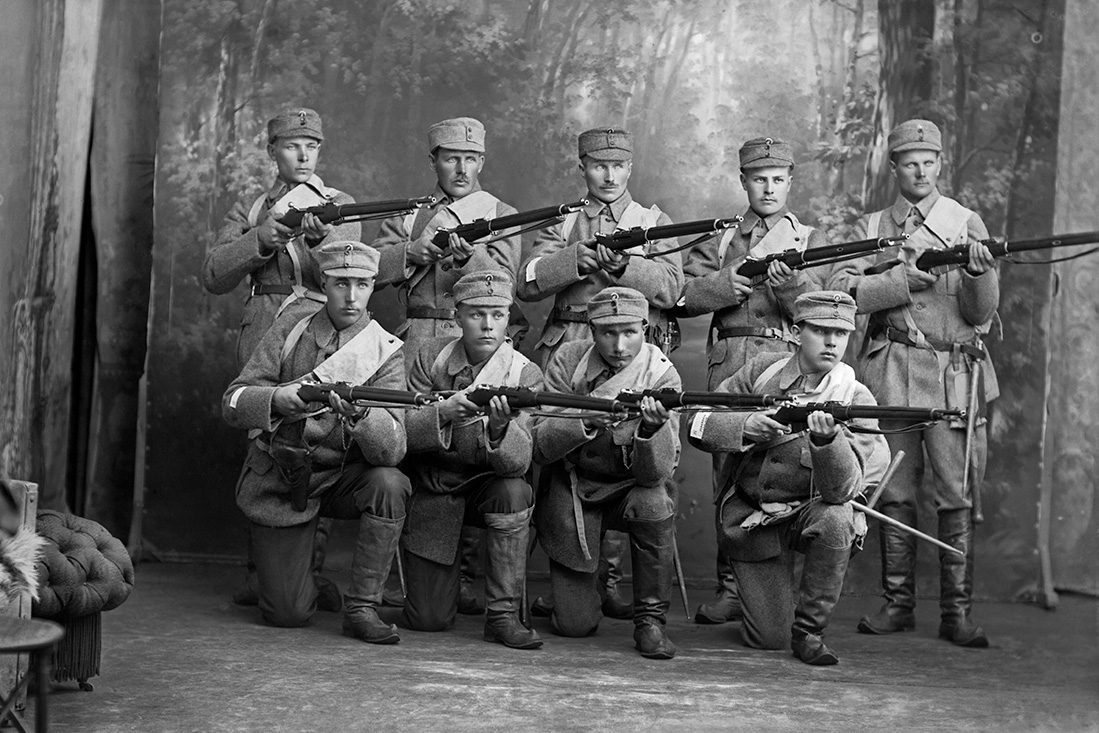 vb4_4847_18_netti Martti Boman and eight other soldiers at the Barsokevitsch Photo Studio, 1918. Finnish boots as military uniform footwear. Photo: Victor Barsokevitsch / KUHMU