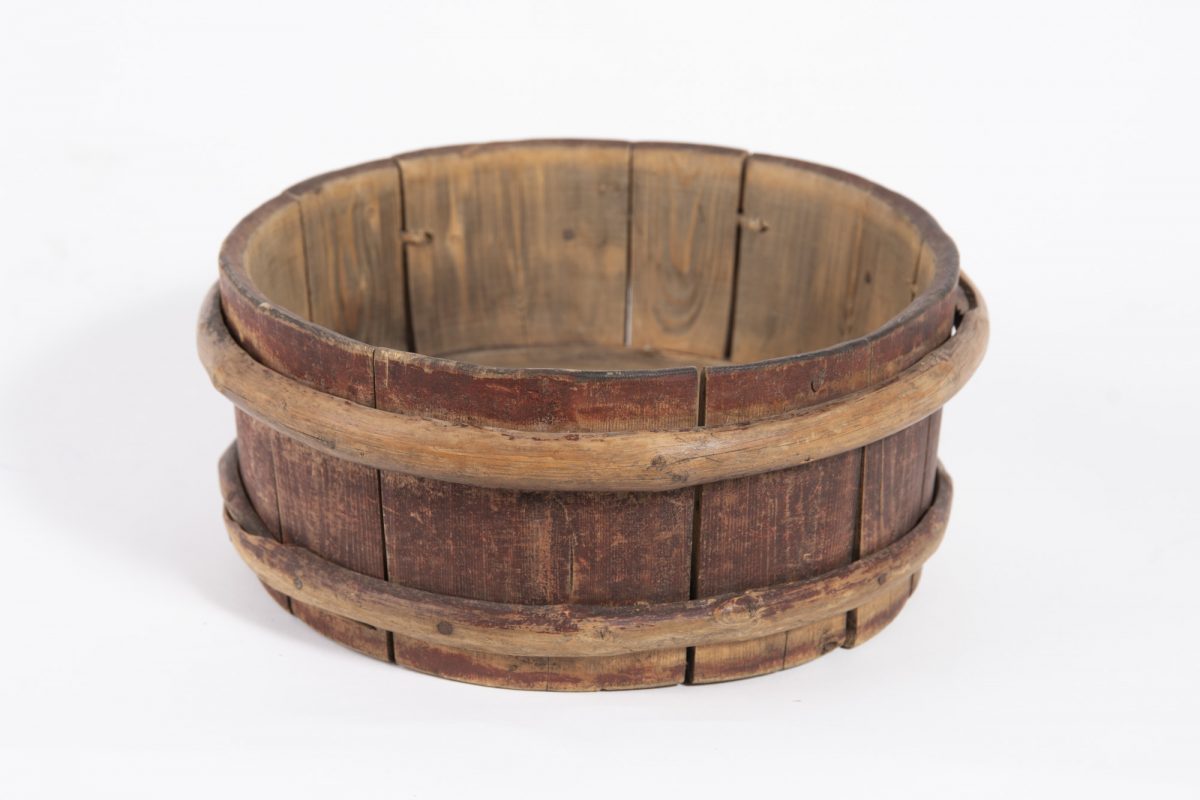 Matala pyöreä puuastia sivulta kuvattuna.