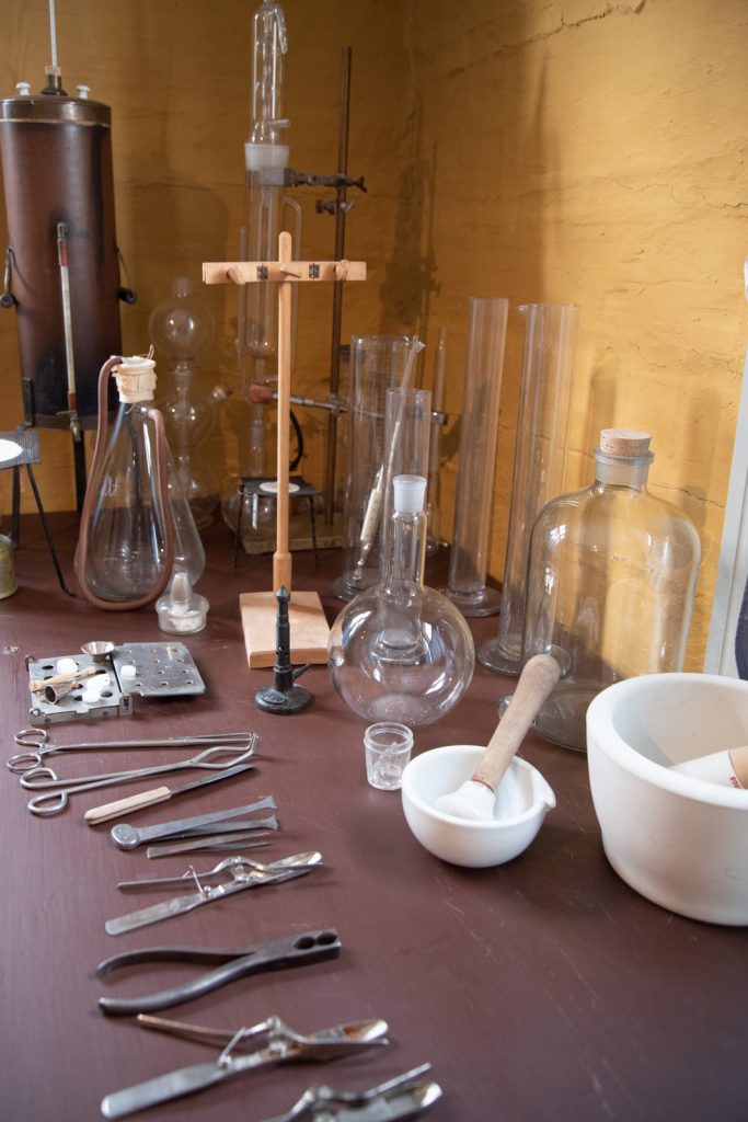 Apteekin laboratorion koeputkia ja muita työvälineitä pöydällä.